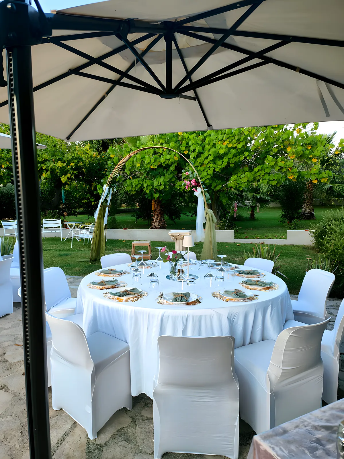 La tavola apparecchiata in giardino sotto l'ombrellone
